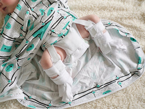 Baby sleeping sack for babies wearing a hip harness brace.